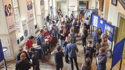 Conference attendees eating, networking and looking at posters on display in the Society's Main Hall