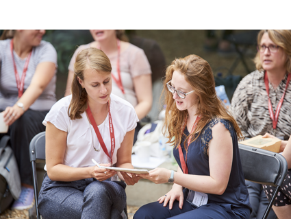 Two women looking at a notebook